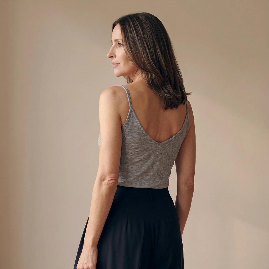 Back view of a melange grey camisole with a deep V back, worn with black tailored pants