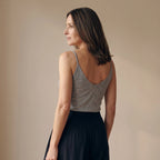 Back view of a melange grey camisole with a deep V back, worn with black tailored pants