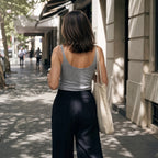 Back view of a melange grey camisole with black tailored pants, carrying a canvas tote bag