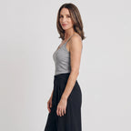 Side view of a melange grey built-in bra camisole with black pleated tailored pants