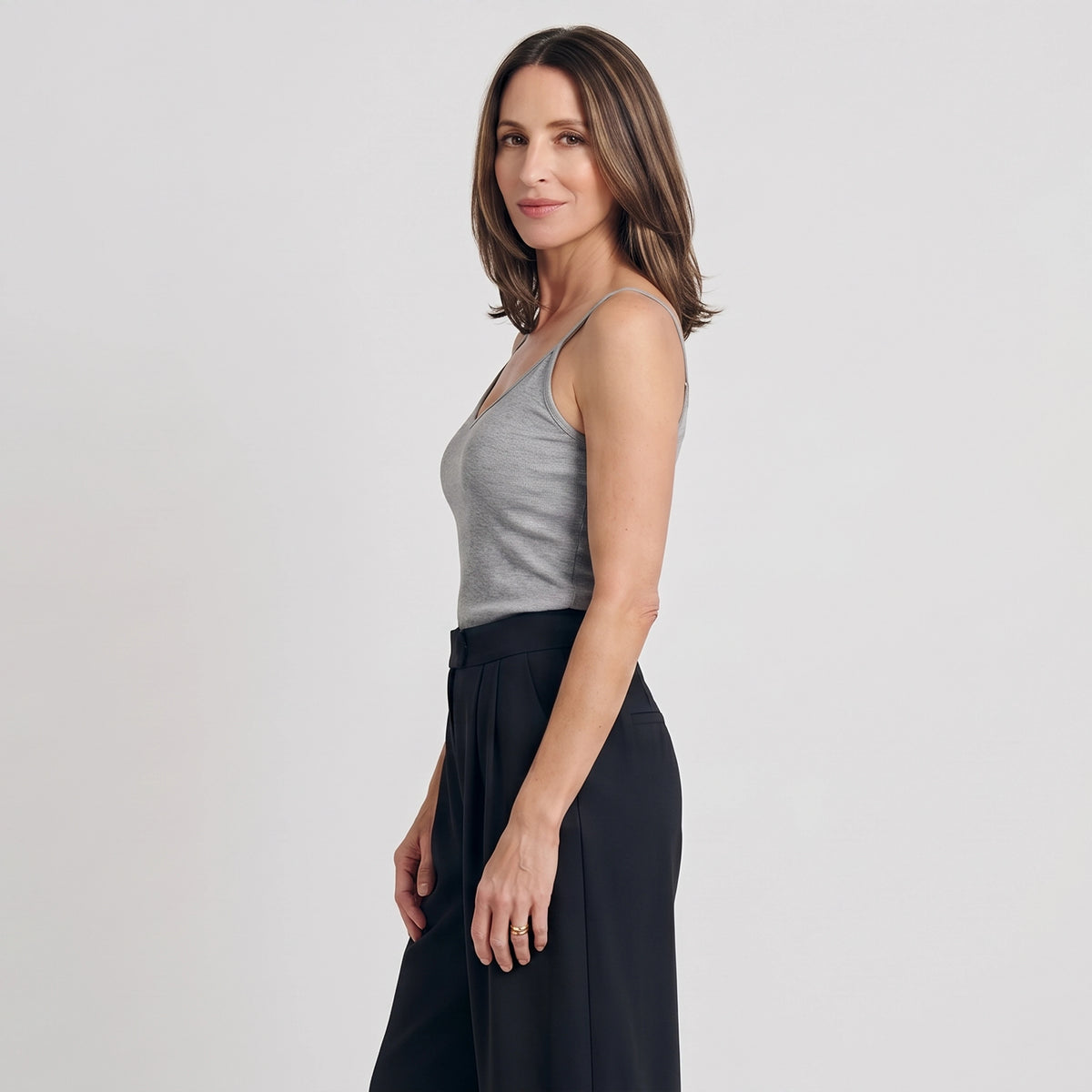Side view of a melange grey built-in bra camisole with black pleated tailored pants