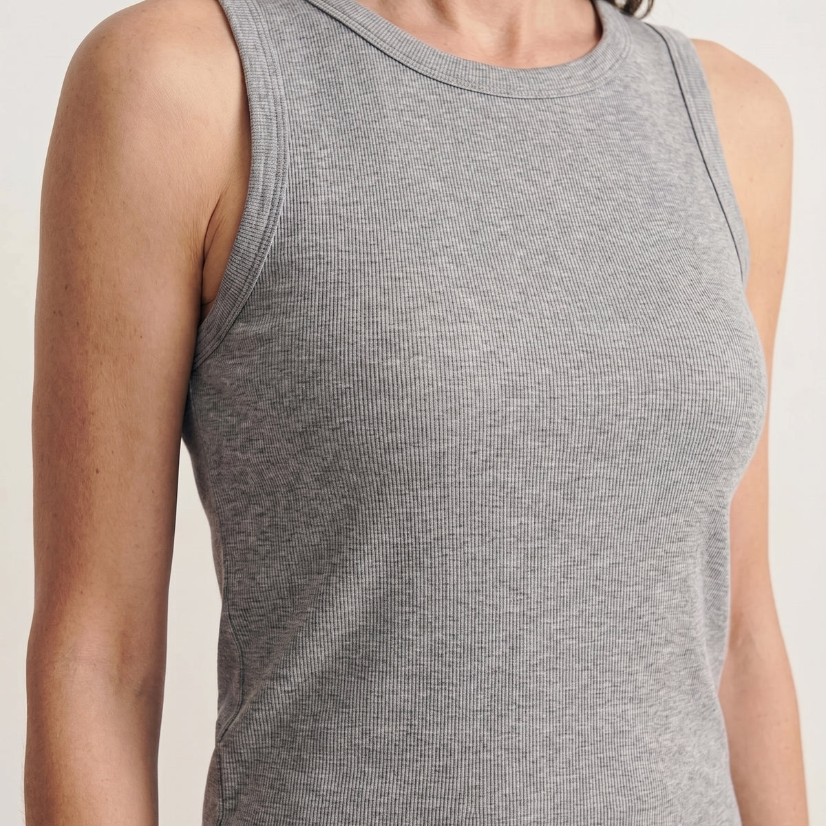 Close-up of melange grey ribbed fabric at the neckline and armhole of the built-in bra tank top