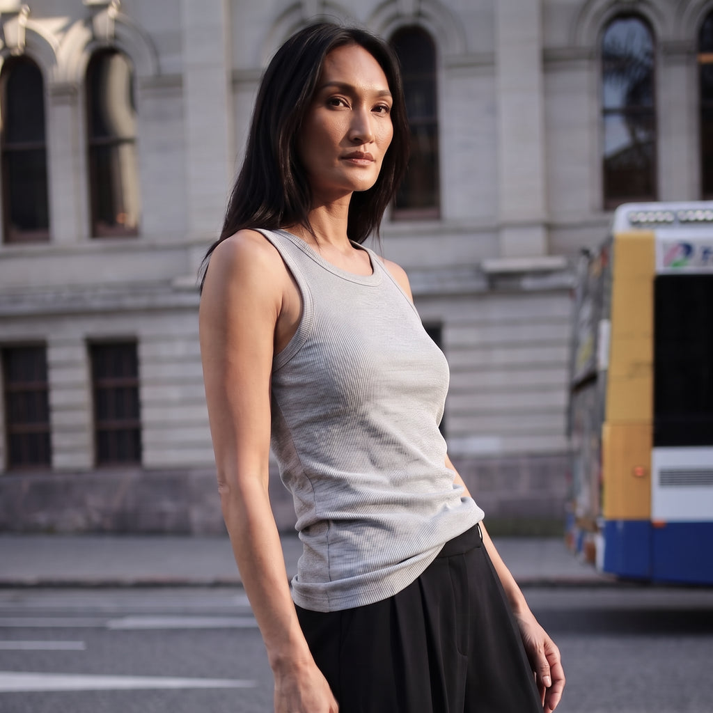 Melange grey ribbed built-in bra tank top with navy pleated pants, walking on a street