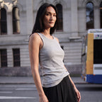Melange grey ribbed built-in bra tank top with navy pleated pants, walking on a street