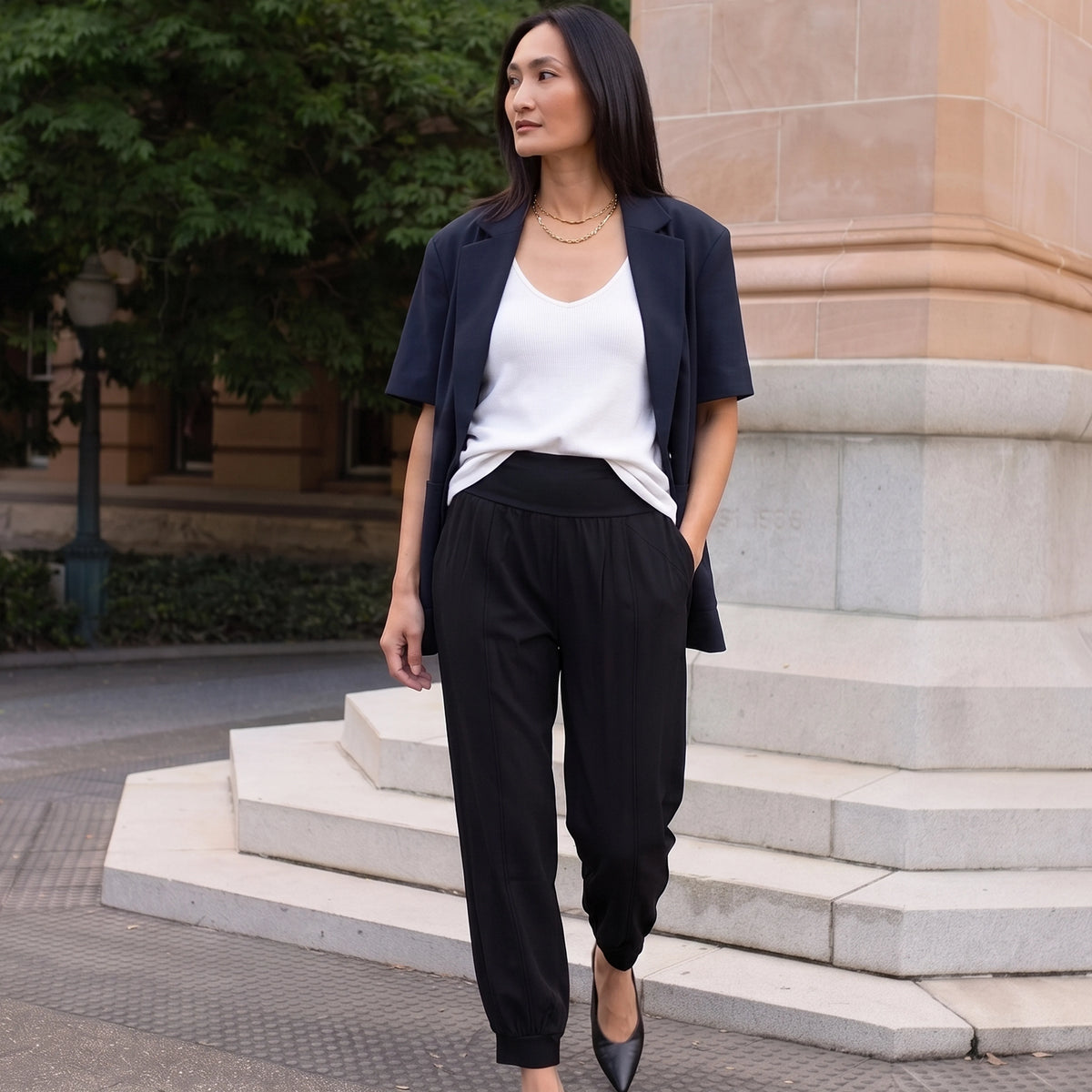 Black woven jogger pants with a navy blazer, white V-neck camisole and gold necklaces, an easy office outfit