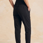 Rare side view of black woven jogger pants showing the waistband, side pocket and tapered leg